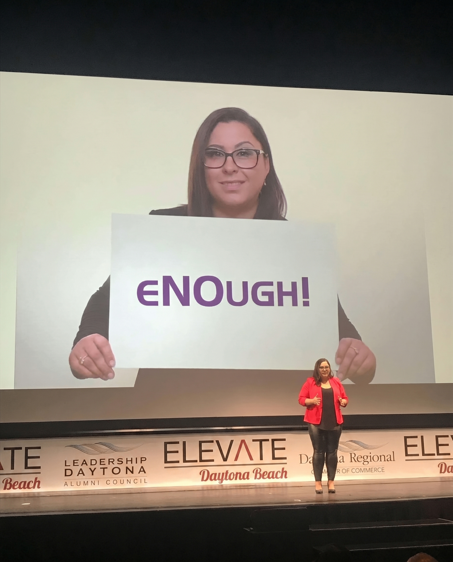 Carmen Ruiz speaking on stage at Elevate Daytona Beach about ending domestic violence